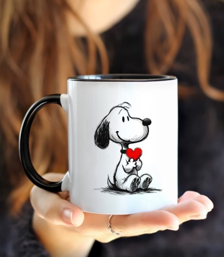 Dziewczyna w czarnym swetrze trzymająca czarny kubek z psem z sercem.  Biały kolor powłoki kubka doskonale kontrastuje z czarną bluzką, a czarny kolor wnętrza i środka kubka dodaje temu urokliwemu wzorowi elegancji.