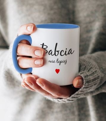 Kubek z nadrukiem: "Babcia, wie lepiej" pokazany w codziennym użyciu.