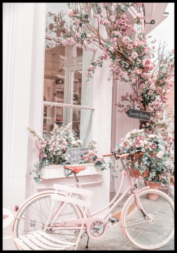 Różowy plakat z pastelowym rowerem pozostawionym przed kawiarnią, na tle przepięknych kwiatów.