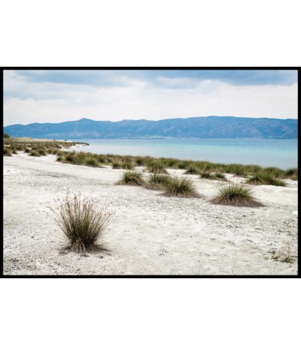 Piękny widok na błękitne jezioro w Turcji oraz piaszczystą plażę porośniętą charakterystycznymi trawami