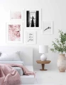 Galeria plakatów wśród której odnajdujemy plakat z różowymi piwoniami. Delikatne peonie doskonale kontrastują z białą ścianą i ciemną grafiką.