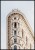 Plakat ze zdjęciem zabytkowego budynku Flatiron Building, który ozdabia Manhattan w Nowym Jorku